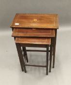 An Edwardian mahogany nest of tables and a walnut coffee table