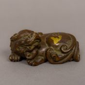 A Chinese gold splash bronze scroll weight Formed as a dog-of-fo. 7 cm long.