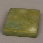 A Chinese carved jade box Of shallow rectangular form, the removable lid carved with a dragon.