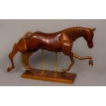 A carved wooden articulated horse Naturalistically modelled,