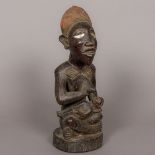 An African tribal carved wooden maternity figure Modelled as a woman breast feeding a child,