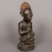 An African tribal carved wooden maternity figure Modelled as a woman breast feeding a child,