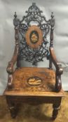 A 19th century Black Forest carved and penwork musical open armchair The pierced carved back