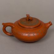 A Chinese Yixing pottery teapot Of squat oval globular form, decorated with calligraphy,