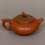 A Chinese Yixing pottery teapot Of squat oval globular form, decorated with calligraphy,