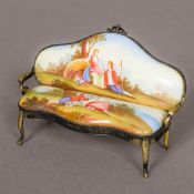 A 19th century Vienna enamel decorated miniature settee Decorated with scenes of a courting couple.