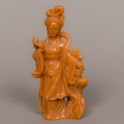 A light brown Chinese hardstone figural carving Formed as young woman standing beside a flowering