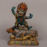 A 19th century Tibetan painted wooden carving Modelled as a deity standing on a bull's back with a