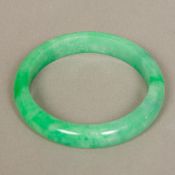 A Chinese carved jade bangle 8 cm diameter.
