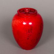 A Bernard Moore pottery vase and cover Of ovoid form with allover red glaze, the underside signed.