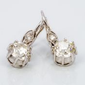 A pair of 14K white gold diamond drop earrings Each claw set drop spreading to approximately 0.