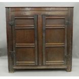A 17th/18th century panelled oak bacon cupboard The twin plank rectangular top above twin panelled