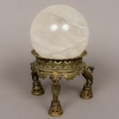 A large rock crystal ball Mounted on a 19th century Indian brass stand,