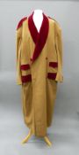 A large camel hair overcoat With burgundy velvet facings, epaulettes and covered buttons.