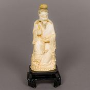 A 19th century Japanese carved ivory okimono Formed as a fisherman seated on rockwork holding a