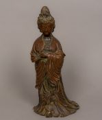 A Chinese patinated bronze figure of Guanyin Typically modelled wearing flowing robes and holding a