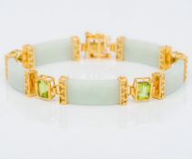 A Chinese silver gilt mounted jade and peridot bracelet Set with calligraphic clasp. 19.5 cm long.