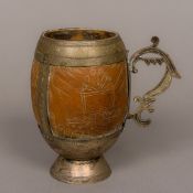 An Eastern unmarked white metal mounted carved coconut cup Decorated with a fish and various floral
