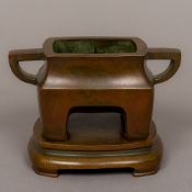 A Chinese patinated bronze censer on stand Of squat angular form,