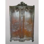 A 19th century French carved oak armoire The curved top rail centred with a wheatsheaf and fruiting