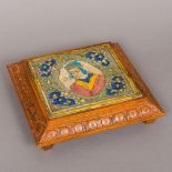 An antique Persian tile Centred with a figural bust bordered with floral sprays,