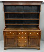 An 18th century oak dresser The rack with moulded cornice above three fixed shelves,