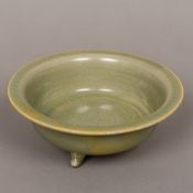 A Chinese celadon ground porcelain censer Of squat three footed form. 17 cm diameter.