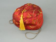 A red silk embroidered smoking cap With covered button and golden tassel,