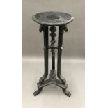 A 19th century ebonised torchere stand The dished circular top above the three rams mask headed