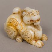 A jade carved mutton fat fo dog Modelled recumbent with incised decoration. 8 cm long.