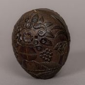 A 19th century carved coconut bugbear Of typical form, with foliate and flowering urn carvings.