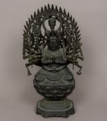 A patinated bronze figure of a multi-armed deity Modelled at prayer in the lotus position,