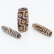 Three Tibetan Dzi beads Of typical decoration. The largest 5.75 cm long.