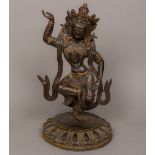 A patinated bronze cabochon stone set figure of Buddha Modelled standing on one leg,