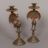 A pair of 19th century Indian brass candlesticks Each formed as a peacock with red and blue enamel