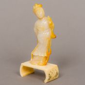 A Chinese carved mutton fat and yellow jade figure of Guanyin Modelled standing in flowing robes,