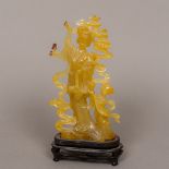 A Chinese carved agate figural group Formed as a woman picking flowers with a child at her side,