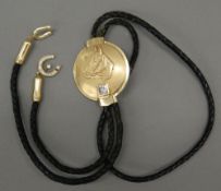 A diamond set unmarked gold (tests as 14/15 ct) mounted bolo tie Decorated with a horse's head with