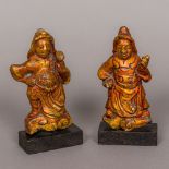 A pair of Oriental gilt heightened lacquered stone carvings Each formed as a deity modelled on a