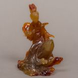 A Chinese agate carving Modelled as Guanyin riding a carp through stylised waves. 13 cm high.
