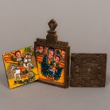 A carved wooden travelling triptych icon Of typical twin hinged form enclosing painted religious