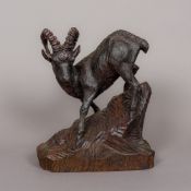 A carved wooden Black Forest mountain goat Naturalistically modelled on a rocky outcrop,