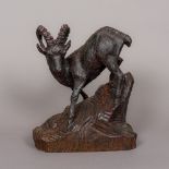 A carved wooden Black Forest mountain goat Naturalistically modelled on a rocky outcrop,