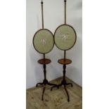 Pair of 19th/20th C mahogany pole screens with circular shelf under oval panels depicting floral