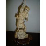 19th/20th C Japanese carved ivory figure of a fisherman on rock, on hardwood base (26cm high)