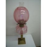 Brass column cranberry glass oil lamp on stepped square base (65cm high)