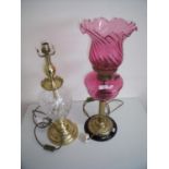 Victorian style cranberry glass electric lamp in the form of an oil lamp and another brass & cut