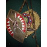 Selection of various African tribal items including hide sheilds, short spears, beadwork necklace,