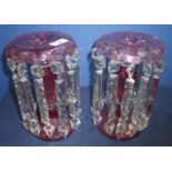 Pair of Victorian cranberry glass lustre candlesticks with clear cut glass drops (25cm high) (1 drop
