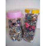 Two large jars containing a large selection of costume jewellery